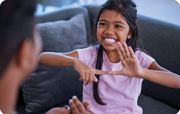 Picture of a small child signing to a ASL interpreter.