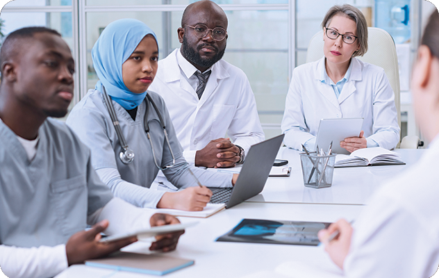 A picture of 4 people wearing medical uniforms listening during medical interpreter training.