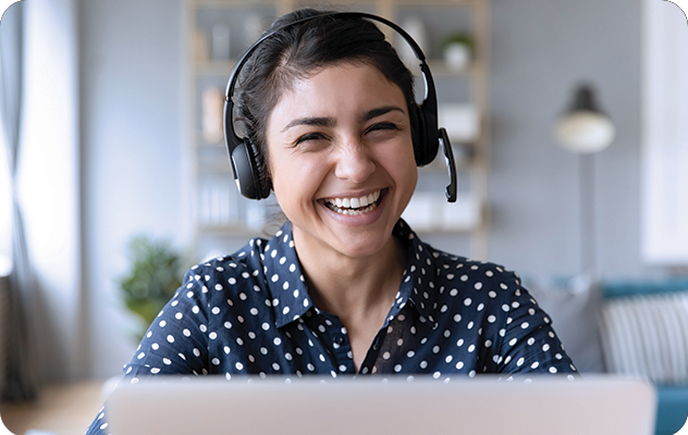 A picture of a female telephone interpreter wearing a headset and smiling at the camera.