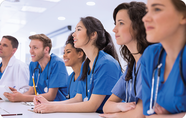 A picture of a group of students sitting at a long desk listening during medical interpreter training.