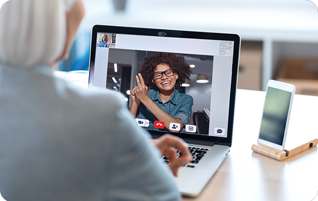 An image of an elderly woman talking to a ASL interpreter via video remote interpreting on a laptop.