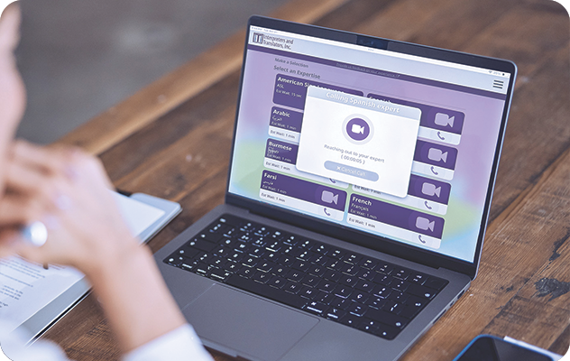 A picture of a person looking at a laptop screen with a call waiting screen for a Spanish Interpreter on our Video Remote Interpreting platform