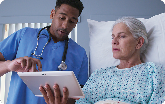 A picture of a young male nurse and an older female patient looking at a tablet together for virtual remote interpreting