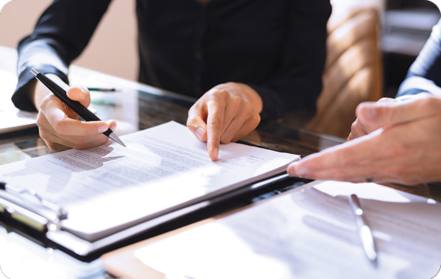 A picture of the two sets of hands pointing to a document that they are reviewing during the document translation process.