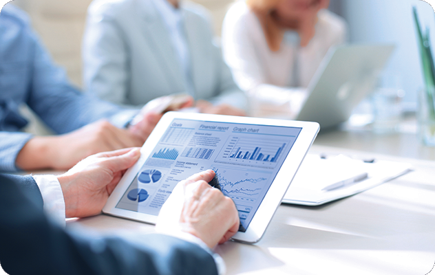 A picture of a person's hands clicking through a tablet with tables and analytics