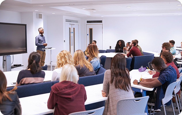 A picture of a college professor talking to a small lecture hall full of diverse students.