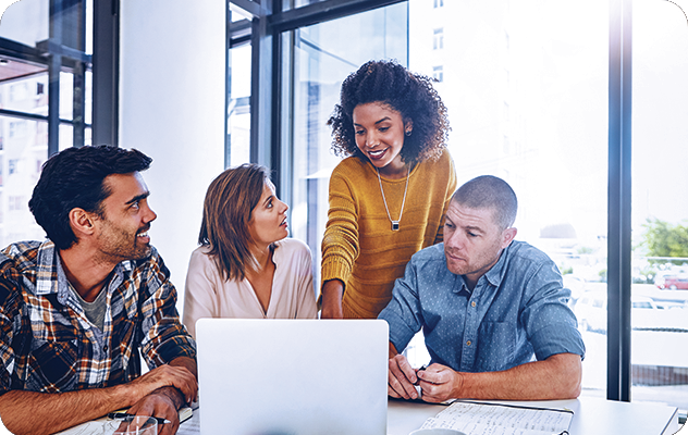 A picture of a four employees, two male and two female looking at a laptop in a conference room trying to figure out how to get language services for their company.