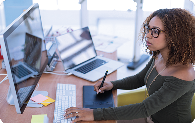 A picture of a young woman working on a desktop computer for