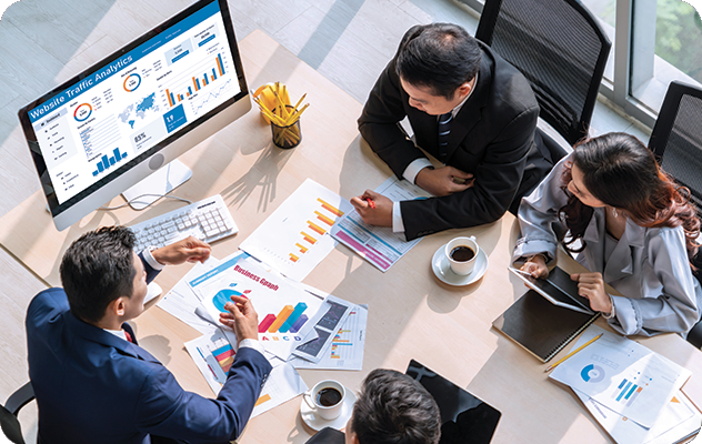 An overhead picture of two men and two women looking at website analytics during multilingual SEO translation.