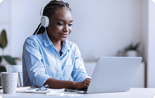 A picture of a woman transcribing an audio clip on her laptop