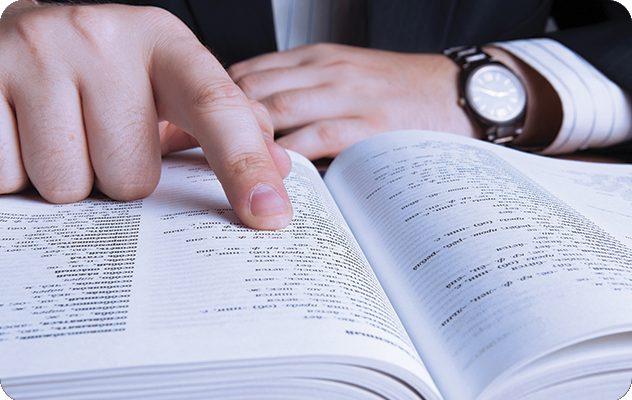 A picture of male hands pointing to words in a glossary.