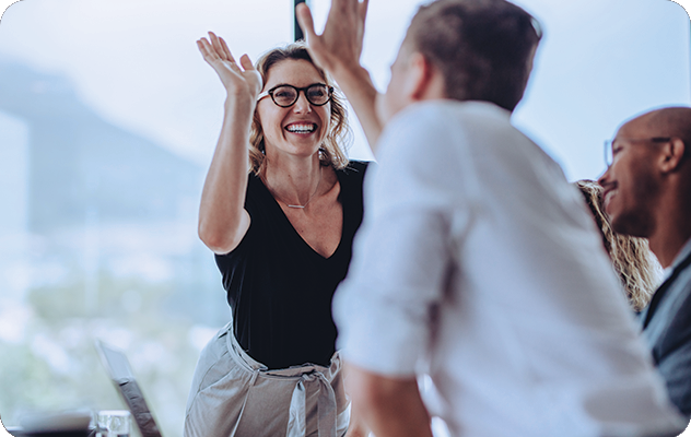 A picture of a man and woman celebrating a job well done during a business meeting