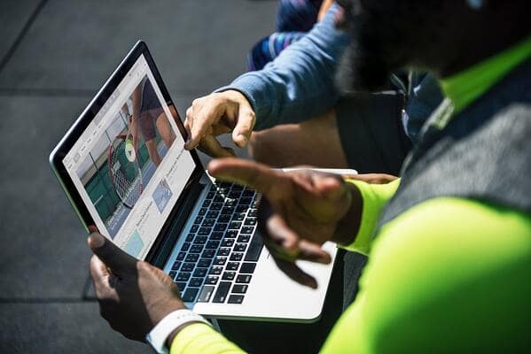 Translators sitting and talking in front of laptop