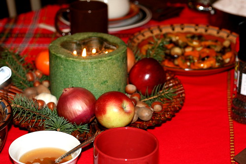  Festive table decorated with candles, fresh fruit, nuts, whole onions and garlic in hope to bring abundance next year