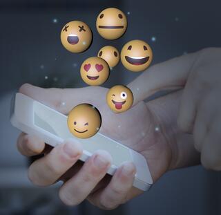 iphon being held with emoji floating into space