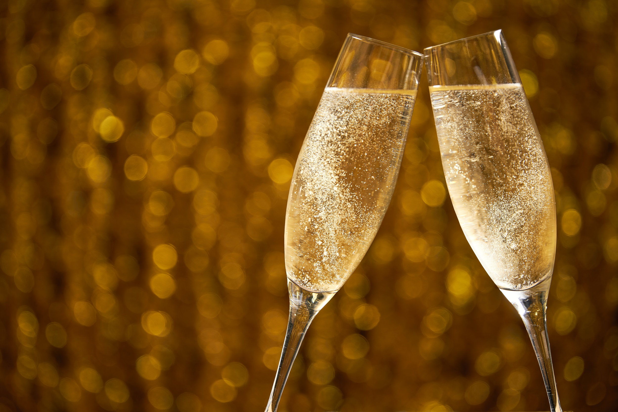 two glasses of champagne on golden stylish background