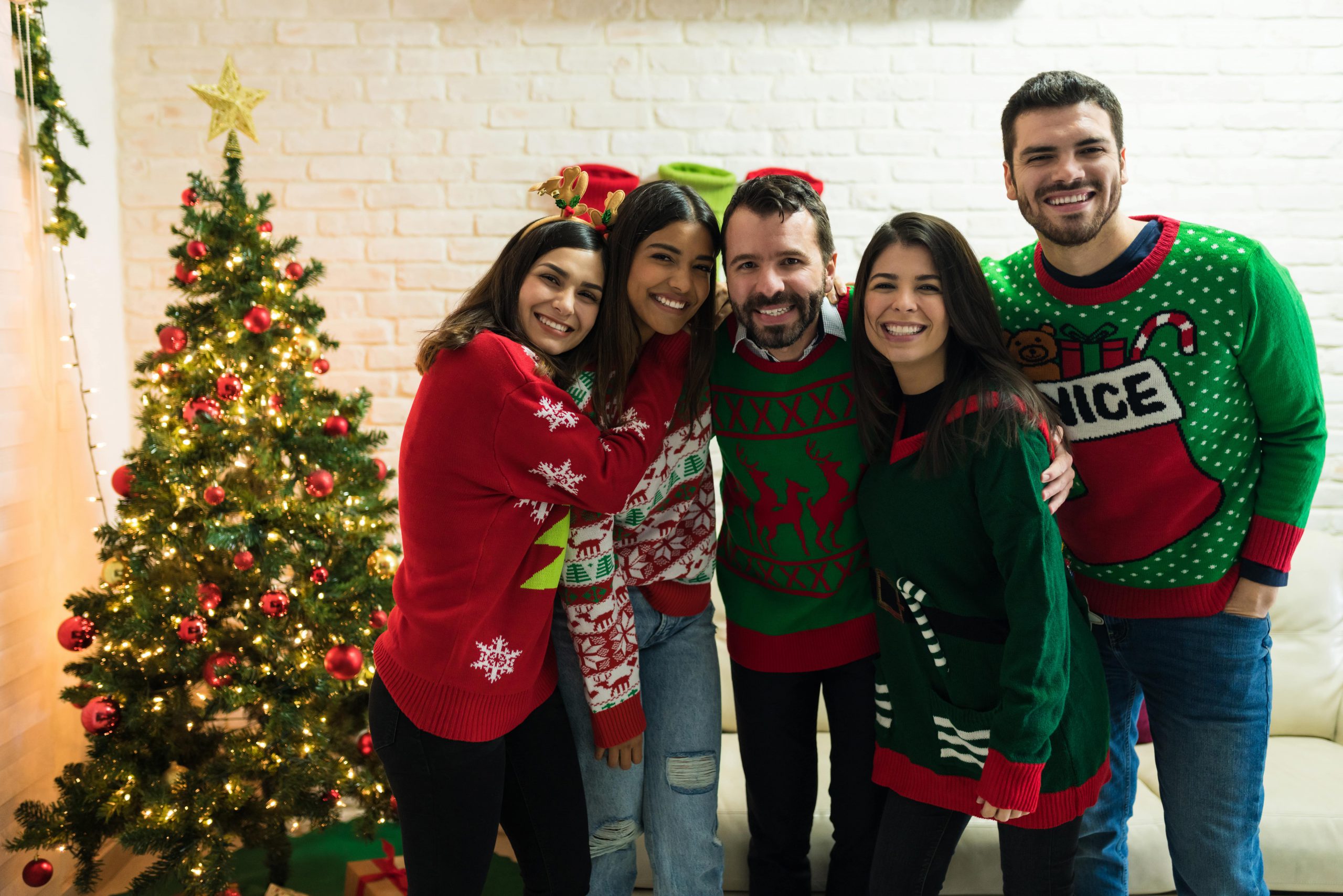 Group of friends wearing ugly Christmas sweaters