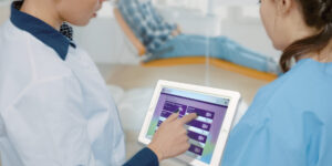 Two healthcare professionals use a tablet to select a language with a VRI interface.