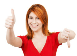 Woman with one thumb pointing up and the other pointing down. 