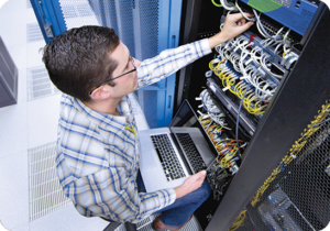 A picture of an IT worker looking at servers.