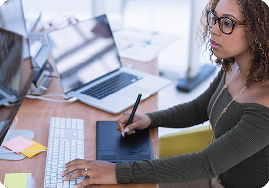 A picture of a woman working on a computer for multilingual desktop publishing services.