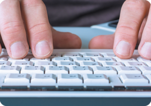 A picture of hands typing on a keyboard during transcription services