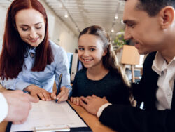 Smiling family signing paperwork