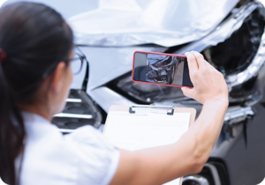 A picture of a woman taking accident pictures on her phone for insurance purposes. iTi provides language solutions for the insurance industry.